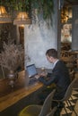 Young caucasian business man in formal suit working on laptop in a bar Royalty Free Stock Photo