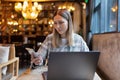 Young Caucasian business woman with blonde hair working on laptop in cafe. College student using technology , online Royalty Free Stock Photo