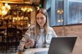 Young Caucasian business woman with blonde hair working on laptop in cafe. College student using technology , online Royalty Free Stock Photo