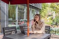 Young Caucasian business woman with blonde hair working on laptop in outdoor cafe. College student using technology Royalty Free Stock Photo