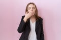 Young caucasian business woman wearing black jacket bored yawning tired covering mouth with hand Royalty Free Stock Photo