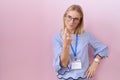 Young caucasian business woman wearing id card beckoning come here gesture with hand inviting welcoming happy and smiling Royalty Free Stock Photo