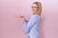 Young caucasian business woman wearing id card pointing aside with hands open palms showing copy space, presenting advertisement Royalty Free Stock Photo