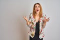 Young caucasian business woman wearing spring floral jacket suit over isolated background crazy and mad shouting and yelling with Royalty Free Stock Photo