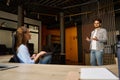 Young caucasian businessman and businesswoman with laptop talking during work Royalty Free Stock Photo