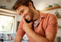 Young caucasian businessman on a call using a cellphone while working from home alone. Happy male businessperson talking