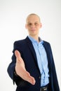 Young caucasian businessman giving hand for handshake, selective focus on hand Royalty Free Stock Photo