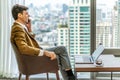 Young caucasian businessman professional talking on phone using laptop while consulting some documents sit at office desk, working Royalty Free Stock Photo