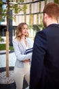 Young caucasian businesswoman looking curiously her interlocutor outdoor in front of business building. outdoor, unofficial,