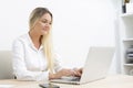 Young Caucasian businesswoman smiling working in front of computer in office Royalty Free Stock Photo