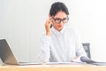 Young caucasian businesswoman working on laptop and thinking  in modern office. Smart businesswomen seriously working on her work Royalty Free Stock Photo