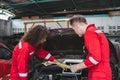 Young Caucasian car mechanic with a checklist, Mechanics in uniform are working in auto service, Technician checking modern car at Royalty Free Stock Photo