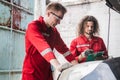 Young Caucasian car mechanic with a checklist, Mechanics in uniform are working in auto service, Technician checking modern car at Royalty Free Stock Photo