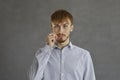 Casual red-haired man showing mouth with zipper secret sign studio shot