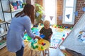 Young caucasian child playing at playschool with teacher