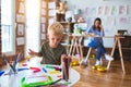 Young caucasian child playing at playschool with teacher