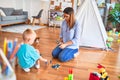 Young caucasian child playing at playschool with teacher