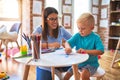 Young caucasian child playing at playschool with teacher