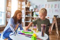 Young caucasian child playing at playschool with teacher