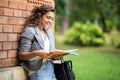 Young caucasian college student with book in college campus. University student going to college