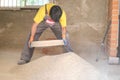 Young builder sieving sand at a construction site.