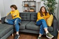 Young caucasian couple angry sitting on sofa at home