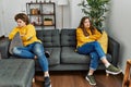 Young caucasian couple angry sitting on sofa at home