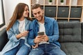 Young caucasian couple buying using smartphone and credit card at home Royalty Free Stock Photo