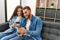 Young caucasian couple buying using smartphone and credit card at home Royalty Free Stock Photo