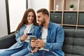 Young caucasian couple buying using smartphone and credit card at home Royalty Free Stock Photo