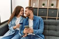 Young caucasian couple buying using smartphone and credit card at home Royalty Free Stock Photo