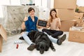 Young caucasian couple with dog holding our first home blackboard at new house doing happy thumbs up gesture with hand Royalty Free Stock Photo
