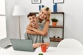 Young caucasian couple hugging and using laptop sitting on the desk at home Royalty Free Stock Photo