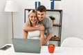 Young caucasian couple hugging and using laptop sitting on the desk at home Royalty Free Stock Photo