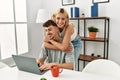 Young caucasian couple hugging and using laptop sitting on the desk at home Royalty Free Stock Photo