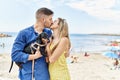 Young caucasian couple kissing and hugging with dog at the beach Royalty Free Stock Photo