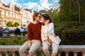 Young Caucasian couple relax in park sitting on ballustrade. Romantic date in Valentine& x27;s Day Royalty Free Stock Photo