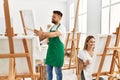 Young caucasian couple smiling happy drawing at art studio Royalty Free Stock Photo