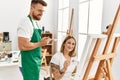 Young caucasian couple smiling happy drawing at art studio Royalty Free Stock Photo