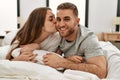 Young caucasian couple smiling happy and kissing on the bed at home Royalty Free Stock Photo