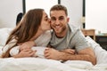 Young caucasian couple smiling happy and kissing on the bed at home Royalty Free Stock Photo