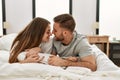 Young caucasian couple smiling happy and kissing on the bed at home Royalty Free Stock Photo