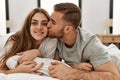 Young caucasian couple smiling happy and kissing on the bed at home Royalty Free Stock Photo