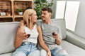 Young caucasian couple smiling happy toasting with red wine at home Royalty Free Stock Photo