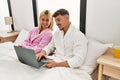 Young caucasian couple smiling happy using laptop sitting on the bed at home Royalty Free Stock Photo