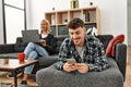 Young caucasian couple smiling happy using laptop and smartphone sitting on the sofa at home Royalty Free Stock Photo