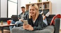 Young caucasian couple smiling happy using laptop and smartphone sitting on the sofa at home Royalty Free Stock Photo