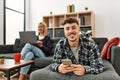 Young caucasian couple smiling happy using laptop and smartphone sitting on the sofa at home Royalty Free Stock Photo