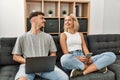 Young caucasian couple smiling happy using laptop and smartphone sitting on the sofa at home Royalty Free Stock Photo