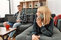 Young caucasian couple smiling happy using laptop and talking on the smartphone at home Royalty Free Stock Photo